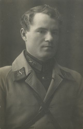 Неизвестный командир-артиллерист, проходивший 
	службу в одном из стрелковых полков 27-й стрелковой дивизии, со знаками различия 3-й категории (соответствует командиру взвода) на петлицах с полем малинового цвета. На 
	петлицах пальто использованы погонные спецзнаки РИА